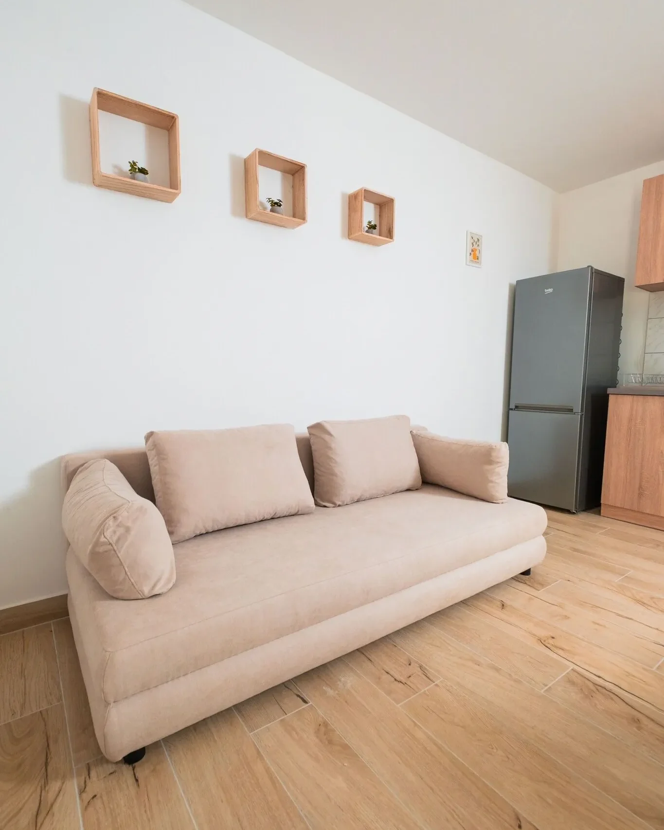 modern nappali bézs kanapéval és konyhasarokkal