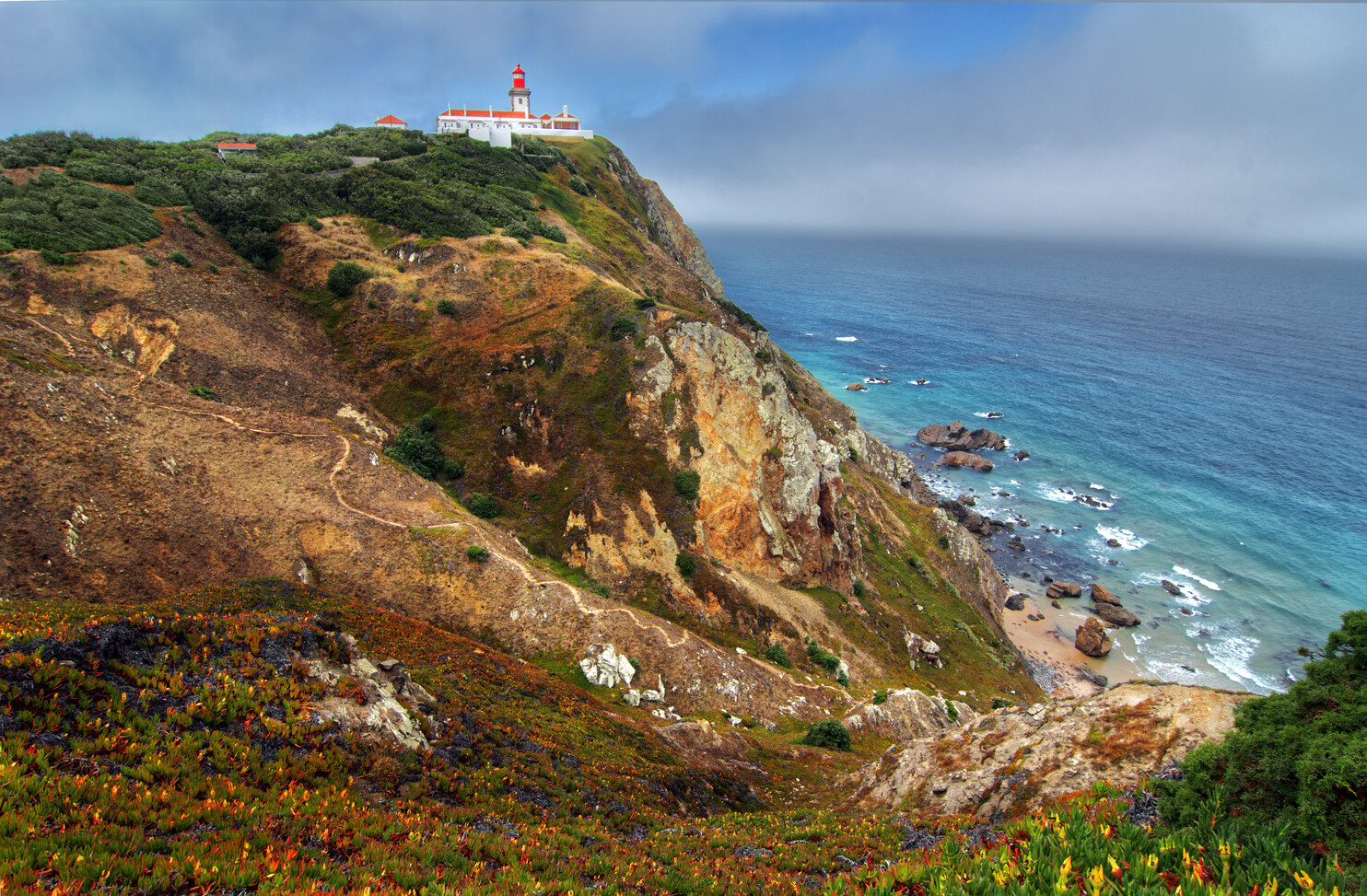 Hatalmas sziklák és az Atlanti-óceán partvidéke a portugáliai Praia da Ursa strandon, Cabo da Roca közelében